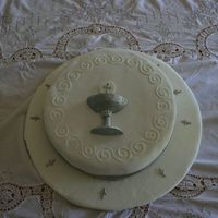 First Communion this cake, and base are covered in fondant. The chalice and host are also made with fondant and painted in luster dust. the small crosses...