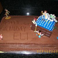 Toy Story I made this cake to look like Andy's bedroom with a lot of the characters all around the bed. The bed is a cake also with Hershey bars...