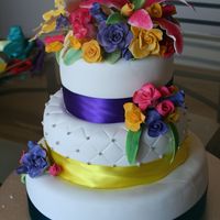 White Cake With Sugarpaste Flowers I made this for my brother in-laws wedding. First attempt at the lillies. The ribbon colours were chosen to match the bridesmaids dresses...