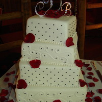 Square Wedding 8, 10, 12, 14 in square covered in fondant with buttercream accents. Black beads and fondant pearls. Red rose petals.