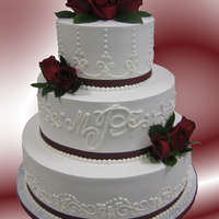 Tt's Wedding Cakes 28 Buttercream Icing, free-hand scrollwork and initial. Real Roses and real ribbon.