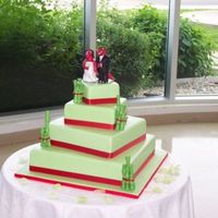 4 Tier Raptor Wedding Cake With Bamboo Chocolate mint with mint green fondant and fondant bamboo wrapped in ribbon and a clay raptor bride & groom.