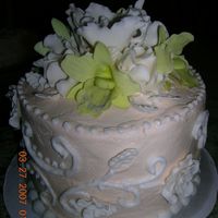 Top Tier Of Wedding Cake top tier of wedding cake: buttercream icing, flowers (pale green orchids and white fancy flowers) are made of gum paste.