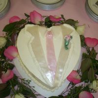 White Tuxedo Coat Bride wanted a white tux with a pink rose. Meringue BC with a marshmallow fondant lapel, tie and rose. Cake was based on the groom's...