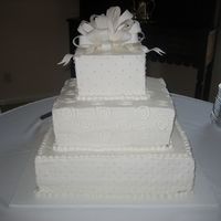 My First Wedding Cake This is my first wedding cake, not very happy with it at all, except for the fondant bow. Had many flaws, and it was damaged on the back...