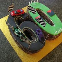 60Th Birthday Race Car Afl Footy Cake Chocolate mud cake, covered in buttercream and chocolate sprinkles. Fondant for the racing track and footy oval.