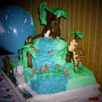 Side View Of Jungle Cake Large tree and rocks are candy clay, "leaves" on large tree broke in route to event site. Palm trees are fancy cookies covered in...