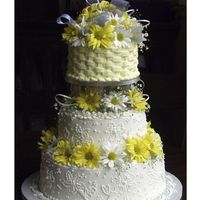 Dots And Daisys Top tier yellow basket weave fresh daisysBottom two tiers white butter cream hand dotted flowers and fresh daisys