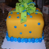 Surprise 3-layer chocolate cake covered with fondant and handmade fondant bow for boy baby shower.