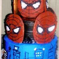Spiderman Cake 1st tier white cake with strawberry jello, top is choc cake with choc frosting, spiderman faces on top are sugar cookies on a stick, th...