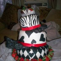Black And White Wedding Fondant with chocolate cake and buttercreme underneath, strawberry bride and groom, ribbon and strawberry accents.