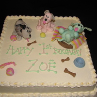 Puppies Join The Party Vanilla cake with super creamy buttercream icing. Topped with playful puppies and puppy toys sculpted from fondant.