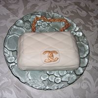 Chanel Purse Chocolate carved cake, fondant quilted purse, gumpaste "chain" handle and gumpaste CC Chanel logo. All edible, painted with gold...