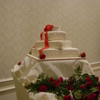 Four Tier Stacked Wedding Cake White Fondant The four tier stacked wedding cake was covered in ivory fondant with different designs on each tier, such as dots, quilting, etc. The bow...