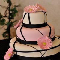 Little Sister's Wedding Moist vanilla cake with a raspberry cream filling. Iced in buttercream and covered in MMF and ribbon. Daisies are done with Mexican Paste...