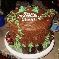 Frog / Stump Cake white cake with chocolate icing. Frogs are made from edible modeling clay and the roses and mushrooms are chocolate leather