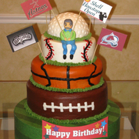 Sports Fan-Atic 4-tier multi-flavored cake frosted with all buttercream icing and fondant character. Wrapped styrofoam base. Bottom tier 12-inch, two-layer...