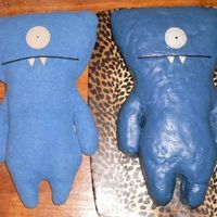 Two Wedgeheads My Ugly Doll posing next to his cake likeness.