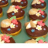Birthday Cupcakes These are vanilla cupcakes with chocolate buttercream. Sea shells are white chocolate with white pearl dust and flowers are Satin Ice...
