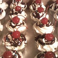 Ice Cream Sundae Cupcakes Vanilla cupcakes with vanilla buttercream, hot fudge sauce, sprinkles and maraschino cherries.