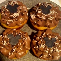 Mickey Mouse Cupcakes Vanilla cupcakes with chocolate buttercream frosting. Topped with white and chocolate sprinkles and a black fondant Mickey ears cutout.
