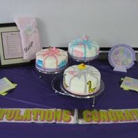 Kenzie's Shower Cake 2 chocolate and 1 white 10 inch cakes iced with buttercream w/ fondant ribbons and bows, Animals are cut outs drawn on icing sheets.