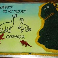 Dino_Connor.jpg Full yellow sheet cake with chocolate dinosaur cake stacked on top. Both with buttercream icing(old Crisco)