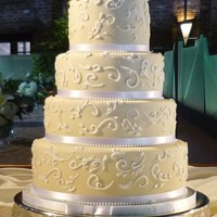 Laura's Cake Vanilla pound cake, carrot cake and red velvet cake. Covered in fondant w/royal icing piping. Fresh flowers on top