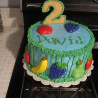 Fruit Cake Chocolate cake iced in buttercream with fondant fruit accents. The 2 is a sugar cookie.