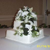 Chocolate Wedding Cake Both tiers chocolate with traditional white buttercream icing, ribbons and pearls along the bottom border, silk flowers to match the...