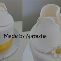 Booties And Daisies 6 inch fruit cake covered in fondX. Booties are made from pastillage, I used my sugarcraft gun for the shoelaces. Thanks for looking!