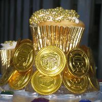 Pirate Booty Cupcake Tower Topper Close up of the topper for the Pirate Booty Cupcake Tower. Glue gunned plastic 'gold' coins to the stand and encrusted the...