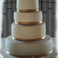 Off White Swiss Dots This is my first wedding cake. Bride wanted off white with white royal icing swiss dots and gold ribbon. 14, 10, 8, and 6 inch 4 layer...