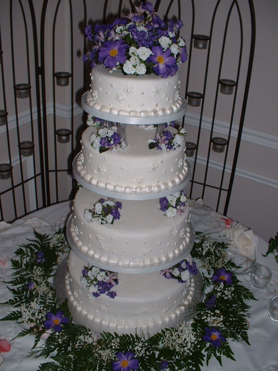 Purple Flowers Wedding Cake Four tiers made with push in pillars (top tier was artificial) and silk flowers. 14-12-10-8 inch tiers.