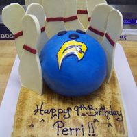 Sabres Bowling Ball For my boss's son who had a bowling party and loves the Sabres. The pins are cut out white chocolate using a stencil.