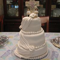 Communion Cake topper is white chocolate cross with petal and pearl dusts on it and two purchased figurines. the rest is fondant.