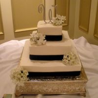 Black And White White bc with buttercream icing. Black ribbon and silk flowers. The bride provided those things. 14, 10, 6 inch cakes. It was my first set...
