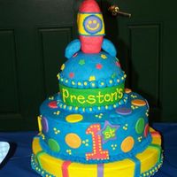 Rocket Cake Stacked chocolate and white cakes decorated with buttercream and fondant accents. The rocket is made out of a rice krispie treat covered in...