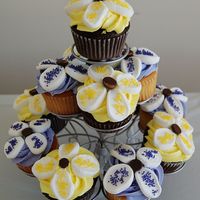 Marshmallow Flower Cupcakes Chocolate and yellow cupcakes with buttercream icing. Flower petals are sliced marshmallows and the center is a chocolate chip.