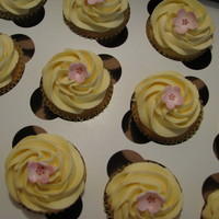 Kelly's Leftover lemon buttercream so made lemon cupcakes....leftover cherry blossoms from wedding cake!!! ha!