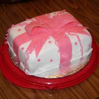 Wilton Course 3 - Package Cake White Fondant over BC to cover cake. Pink fondant bow and decorations.