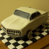 1962 Cadillac Cake was carved from a 1/2 sheet pan, 4 layers. I used blocks spray painted black to lift it up, wheels are doughnuts, covered in mmf.
