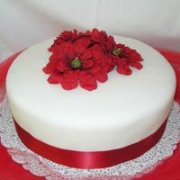 Red Velvet Fondant covered cake with fake silk flowers and ribbon