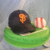 Halloween_2006_052.jpg Cake for son's baseball team. 6 inch round cake with half of ball cake on top. Hat bill is made of cardboard covered with fondant....