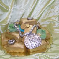 Christmas_2006_149.jpg My son wanted a "bling" cake. Don't ask me why. This is what I came up with. Gold bars are mini loaf pan cakes covered with...