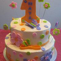 Polka Dots/daisies Cake Done for a 1 year old little girl. Buttercream with fondant accents.