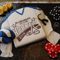 Hockey Jersey Cake was done for the leagues award banquet. The pucks and glove are also cake. All other decorations is made from gumpaste or fondant.