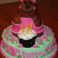 Bear With Rose Buds This cake was made for a 3 year-old's birthday party. The cake is made from the Pooh cake pan. The dress and bow are made of fondanat...