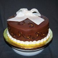 Cappuccino And Ganache Cake A three layer cappuccino cake w/ chocolate ganache filling, frosted with chocolate hazelnut frosting, topped w/ a fondant bow.
