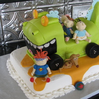 Rugrats The Movie Kids made out of gumpaste, dinosaur is pound cake covered in fondant, bottom cake is white cake, strawberry filling with buttercream. What...